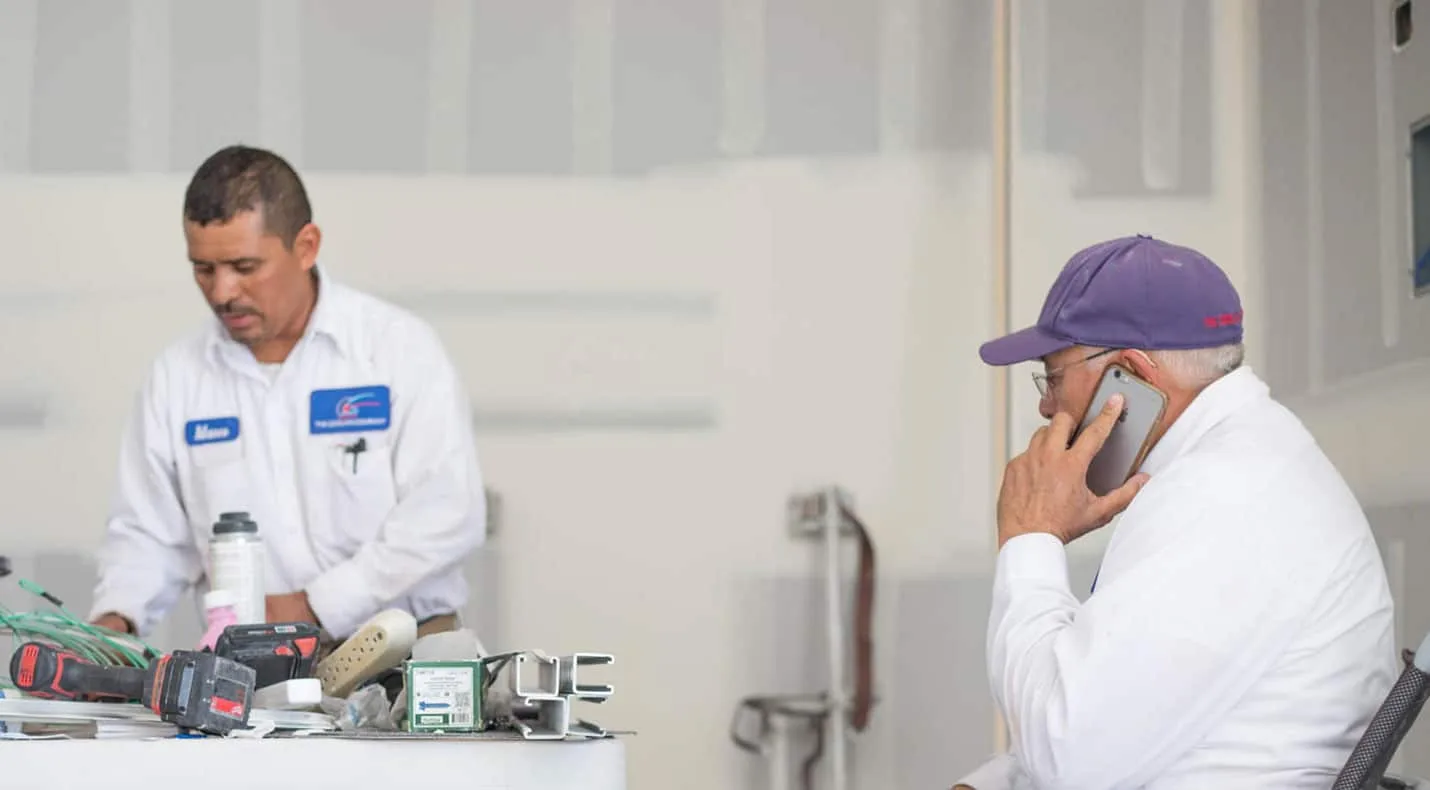 Two Cooling Company technicians working together on an HVAC system