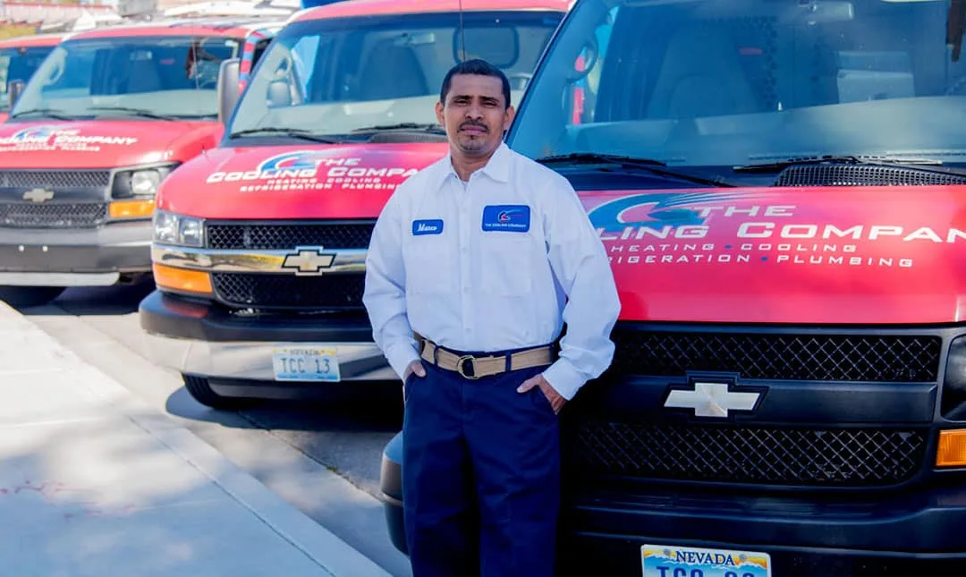 Marco, Lead HVAC Technician at The Cooling Company, standing in front of the TCC service fleet